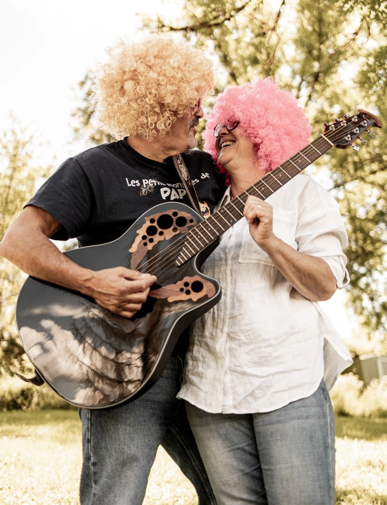 Couple amoureux déguisé avec des perruques qui joue de la guitare lors d'une fête à Annecy photographié par Marine Bourely Photographe