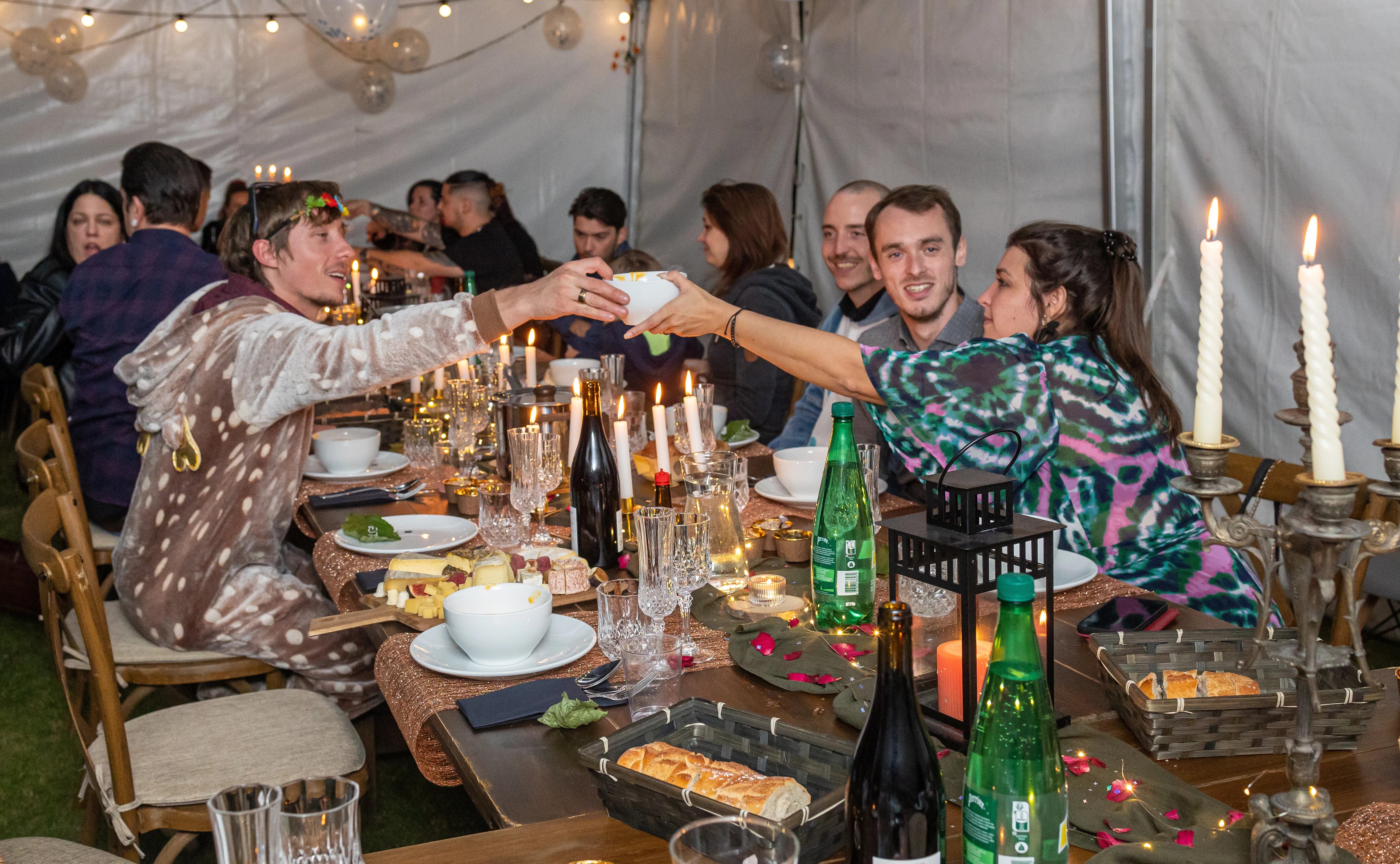 Groupe d'amis déguisés lors d'une fête partageant un repas sous un chapiteau photographié par Marine Bourely Photographe
