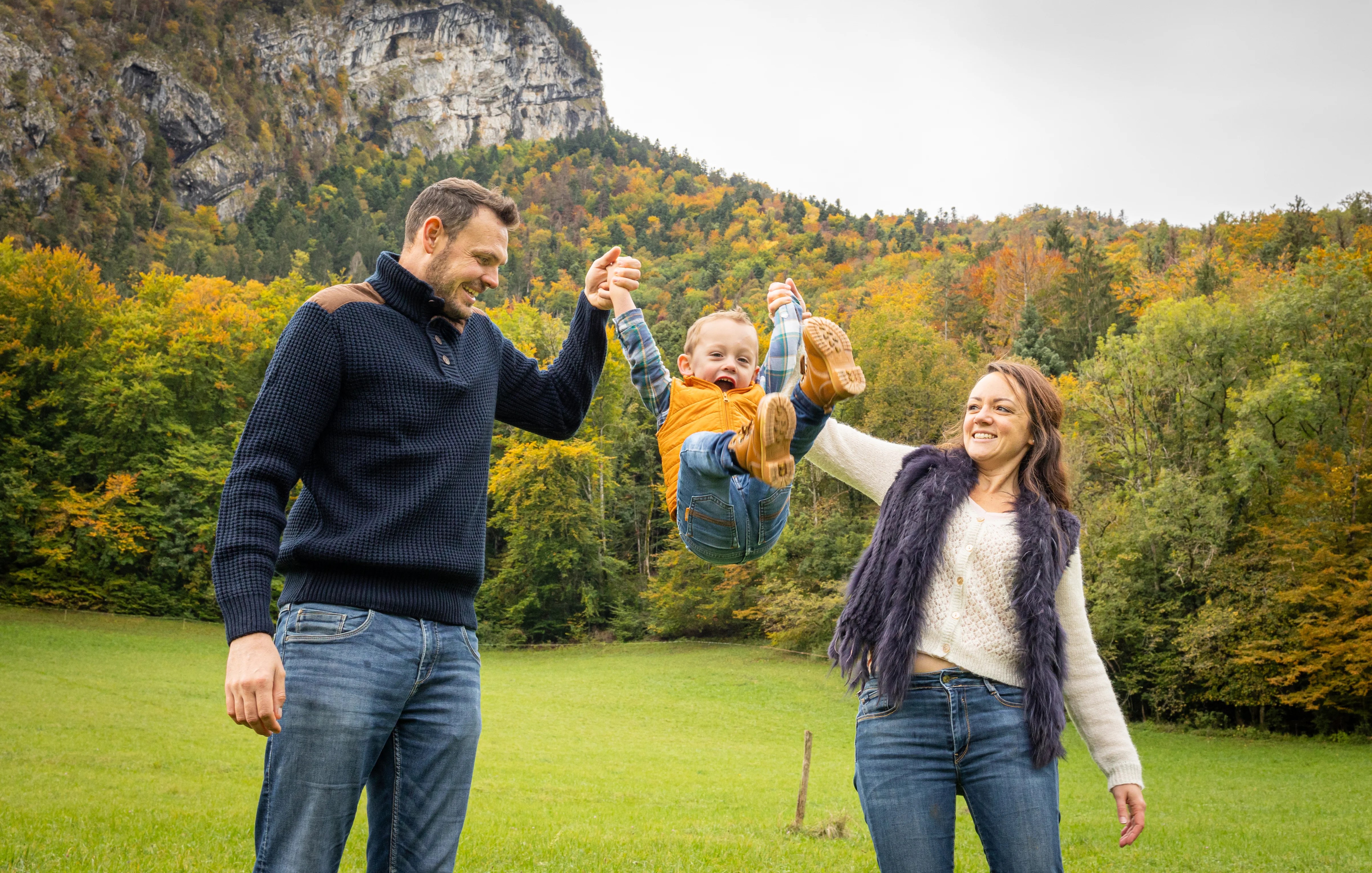 Parents qui font sauter leur enfant à la montagne photographiés par Marine Bourely Photographe
