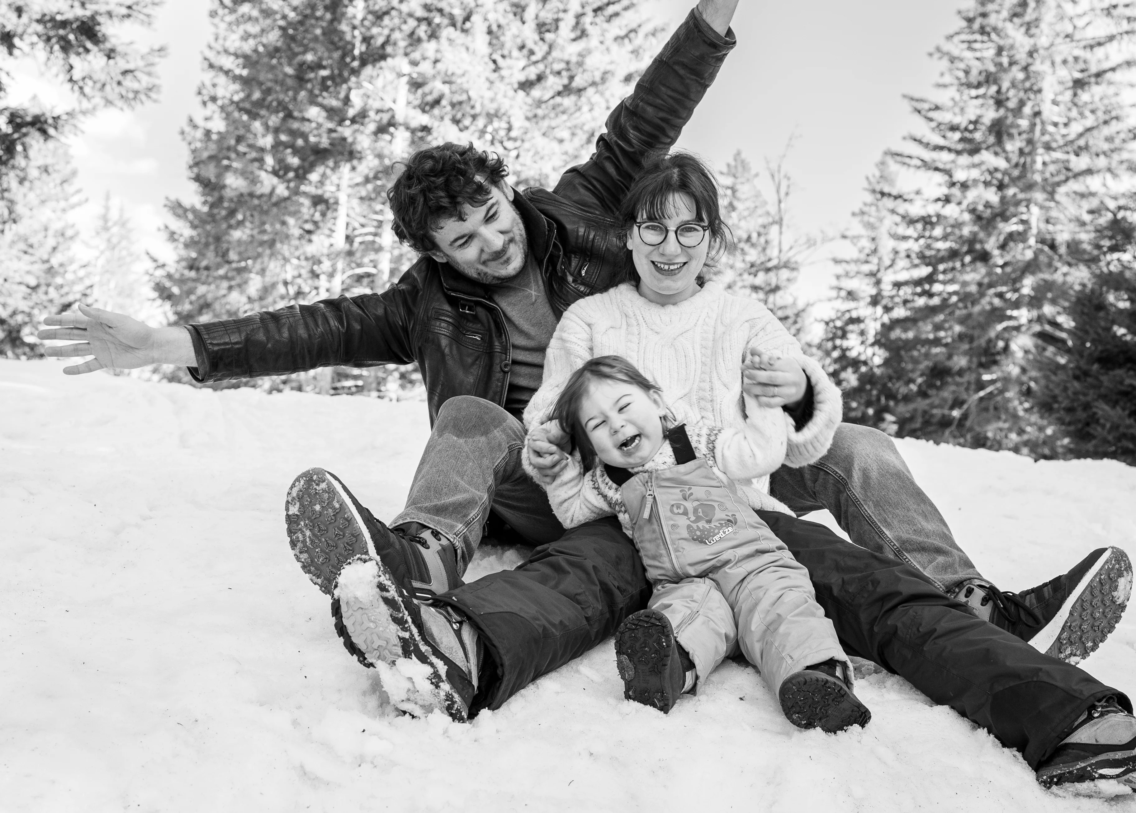 Famille qui joue assis dans la neige photographiée par Marine Bourely Photographe