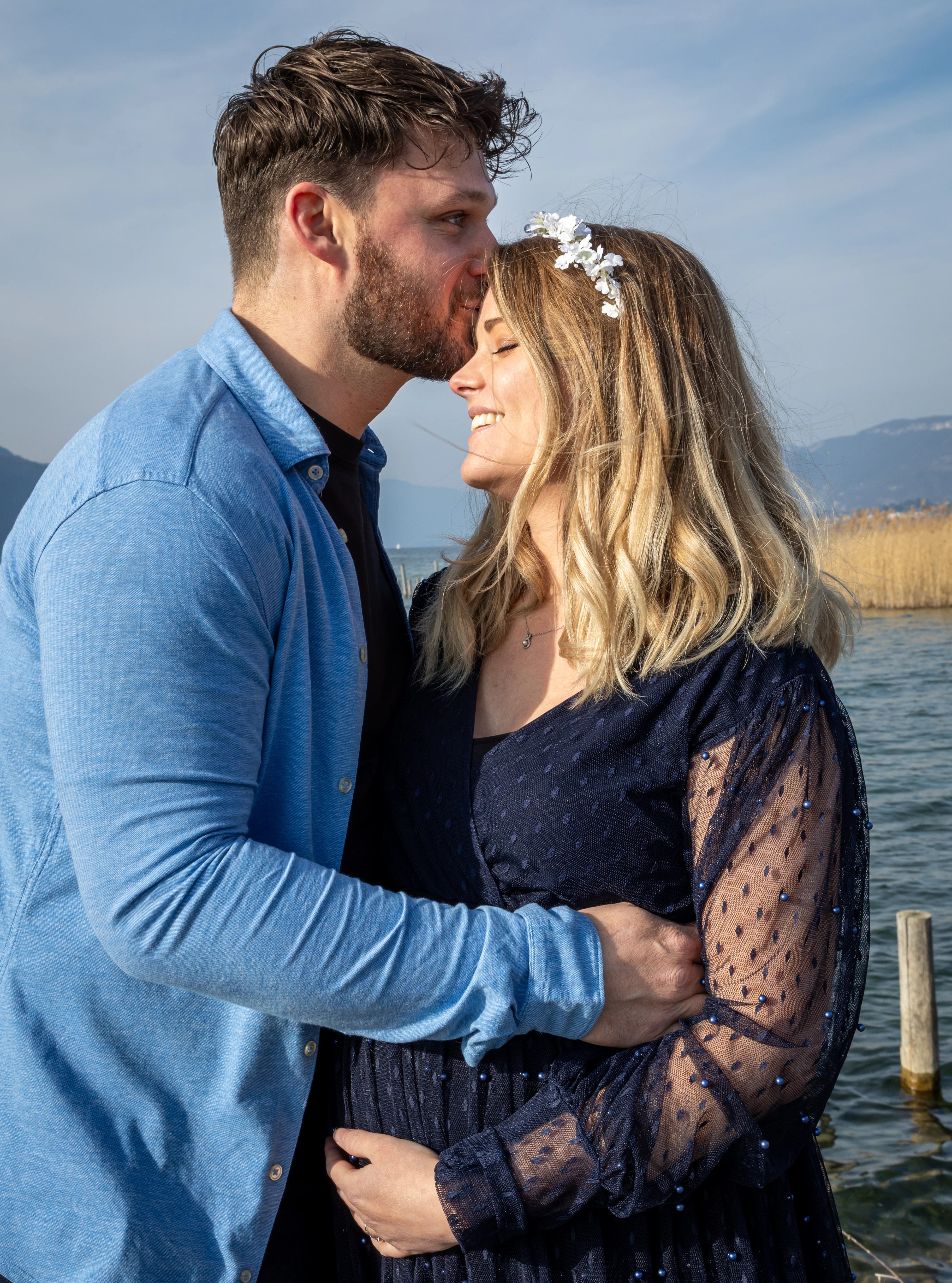Homme amoureux embrassant le front de sa compagne sur un ponton à Aix-les-Bains photographiés par Marine Bourely Photographe