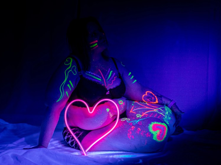 Femme confiante le corps couvert de bodypaint dans le noir lors d'un atelier art photo thérapie photographiée par Marine Bourely Photographe